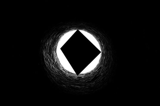 Looking up a well where a black polygon blocks most of the light coming down the well