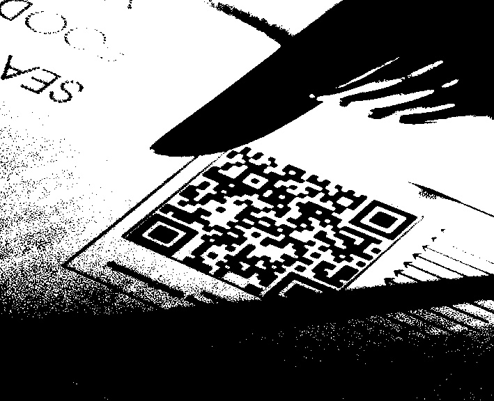 A close-up of a qr code where most of the upper left finder pattern is solid black